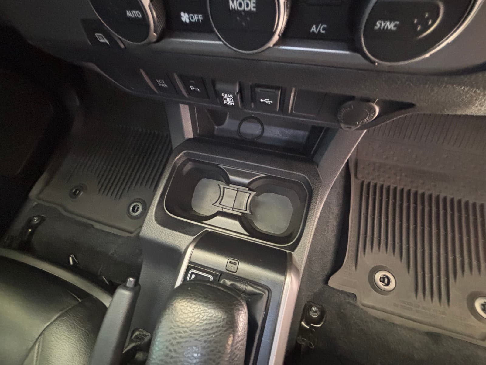 Detailed Toyota Tacoma center console with climate controls and cup holders